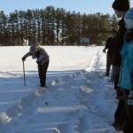 A student checks snow depth.